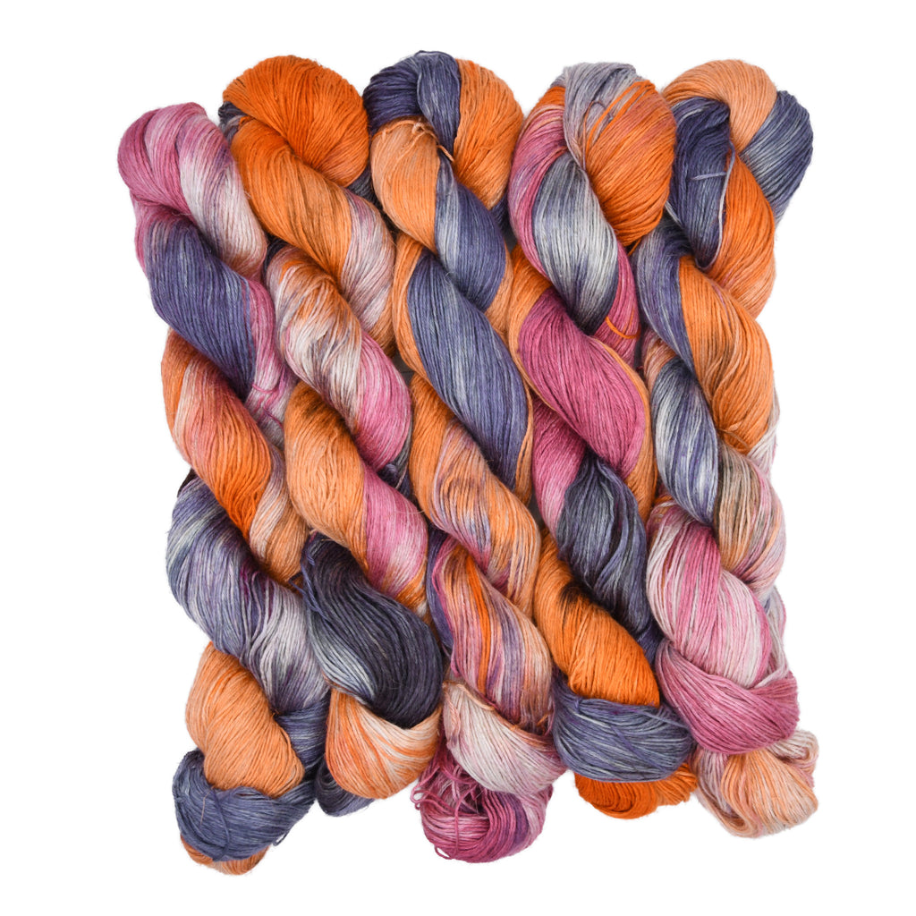 Multicolored yarn skeins braided together on a white background