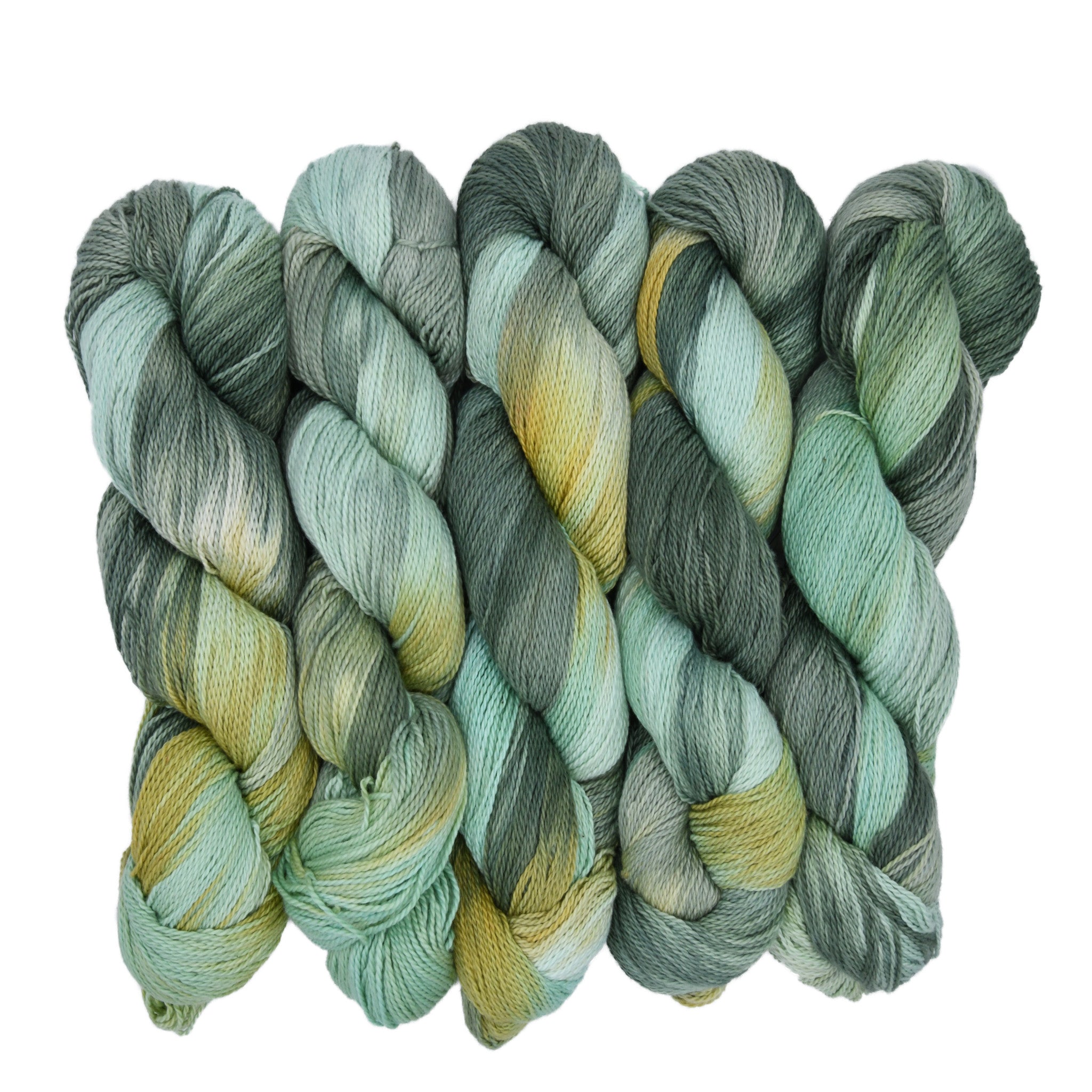 Three skeins of green and gold yarn on a white background