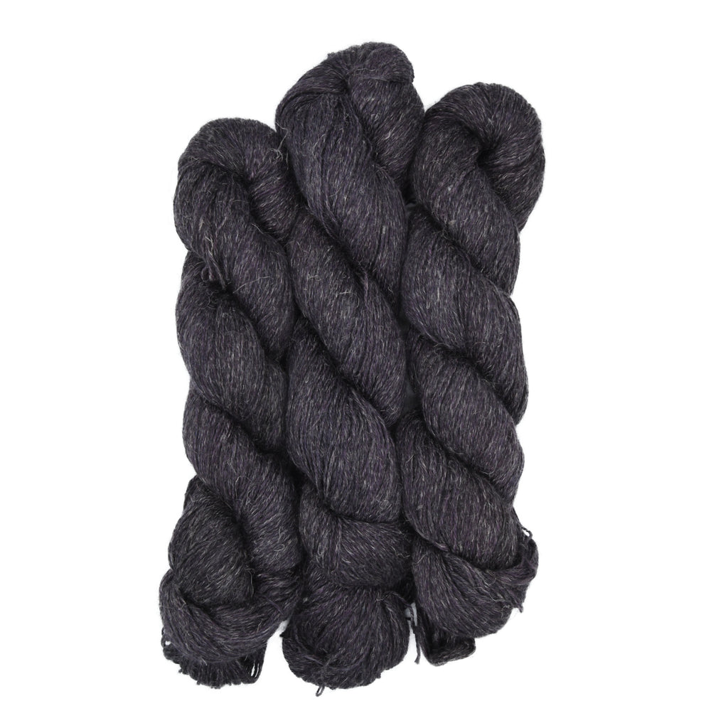 Three skeins of dark brown yarn on a white background
