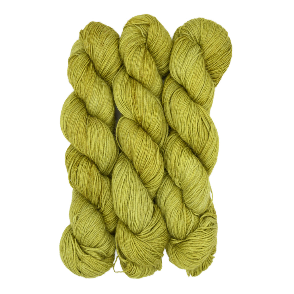 Three skeins of green yarn on a white background
