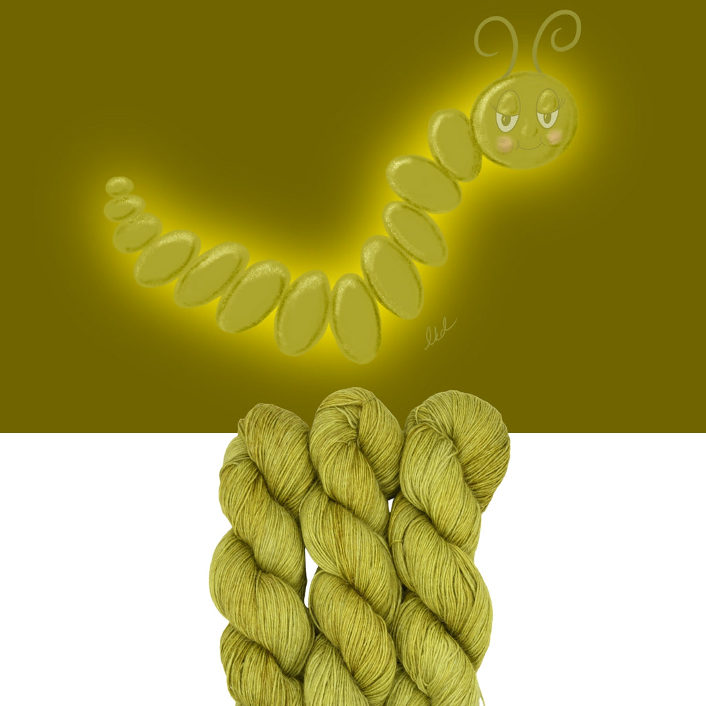 Green hand-dyed yarn skeins with a cartoon caterpillar on a green background