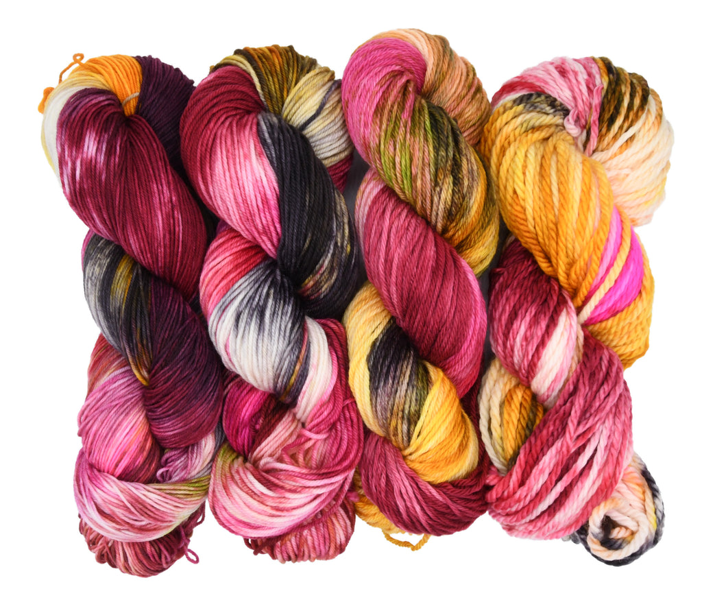 Gordon’s Garden Party a richly layered multicolor colorway by Woolly Headed Ideas. Hand-dyed yarn in Fingering, DK, Worsted, and Bulky weights, featuring yellow, red, deep green, maroon, and dark charcoal gray on a white backround.