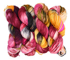 Gordon’s Garden Party a richly layered multicolor colorway by Woolly Headed Ideas. Hand-dyed yarn in Fingering, DK, Worsted, and Bulky weights, featuring yellow, red, deep green, maroon, and dark charcoal gray on a white backround.