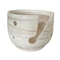 A handmade ceramic contemporary yarn bowl, featuring a marbled clay  on a white background