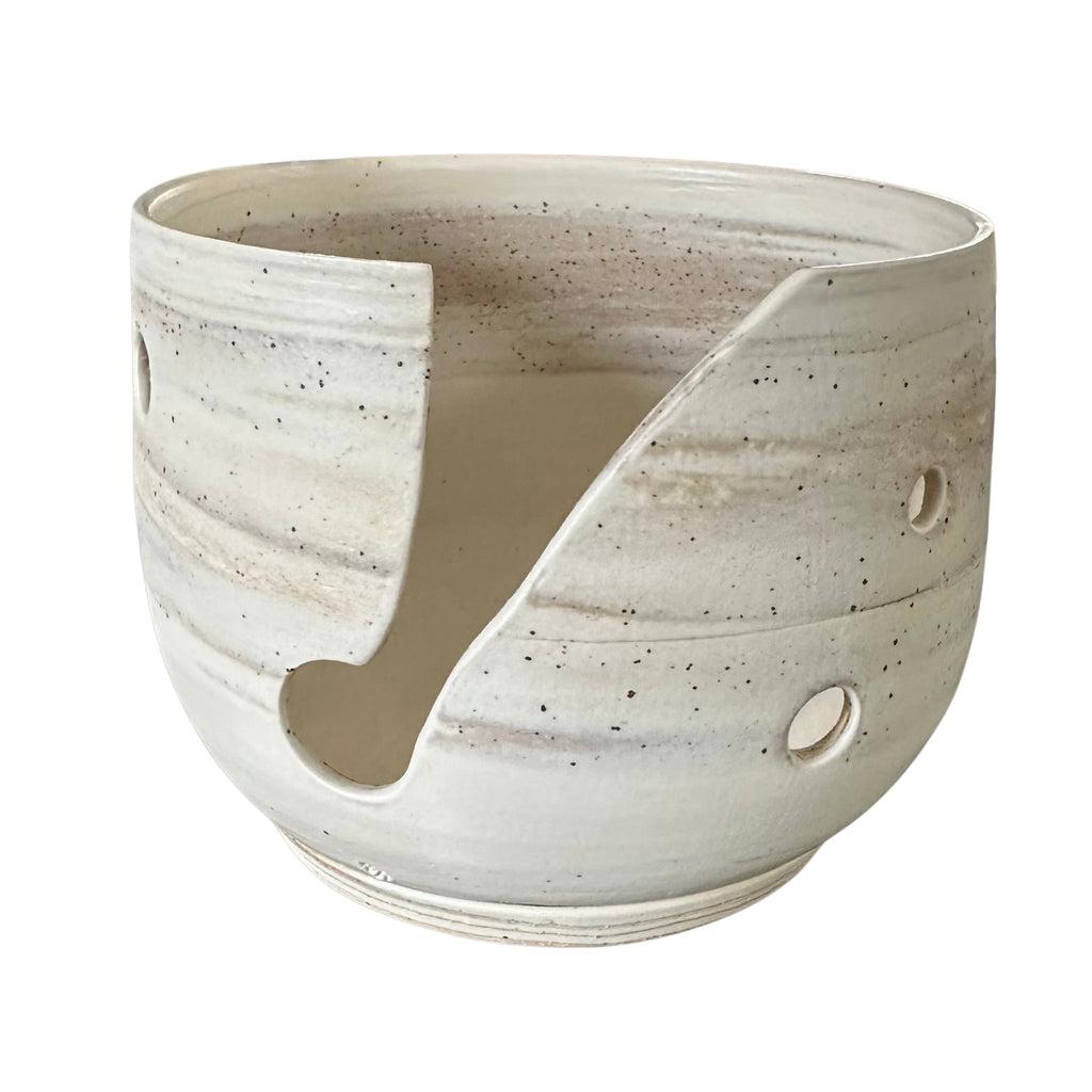A handmade ceramic yarn bowl thrown using marbled clay shown on a plain white background.