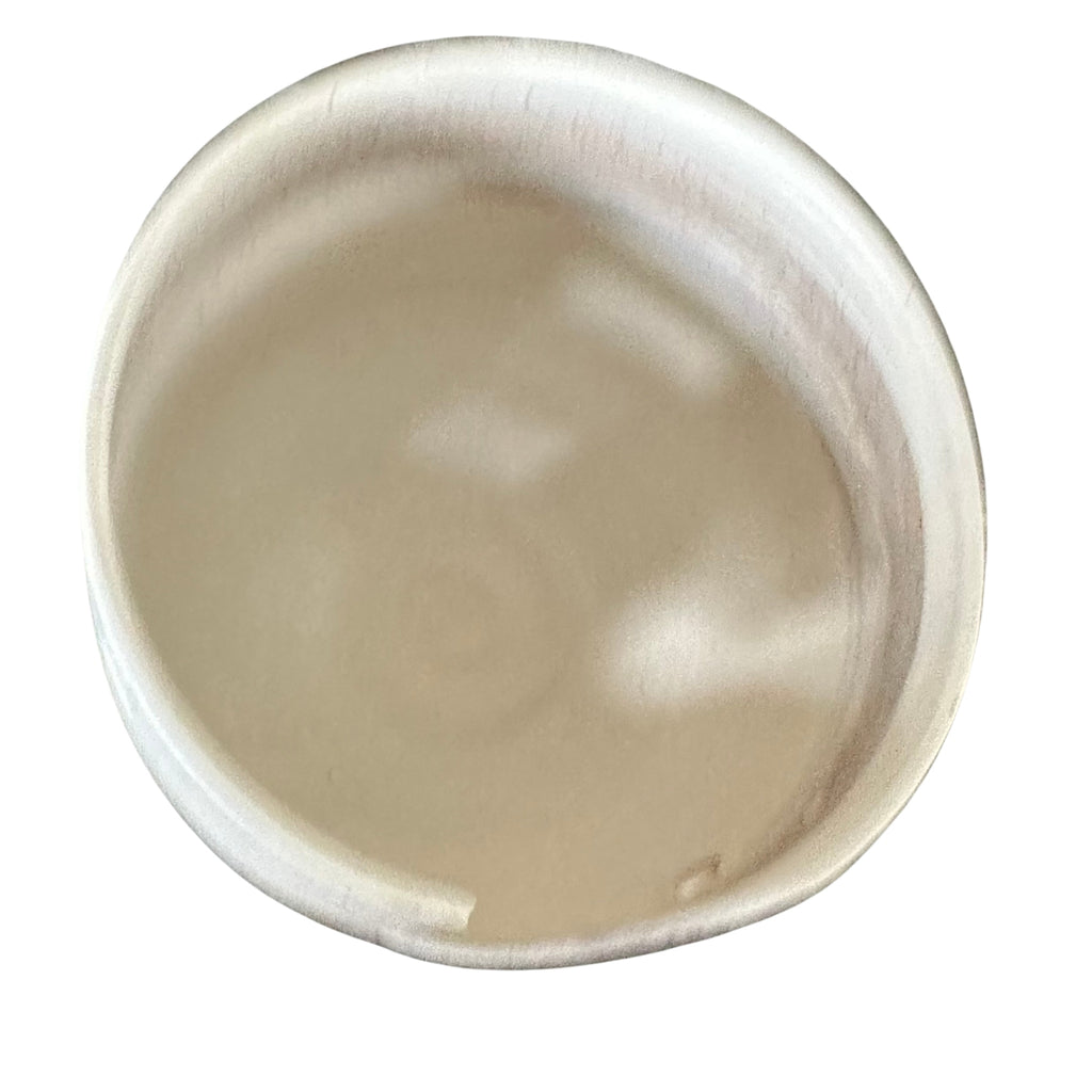 A round, ceramic yarn bowl with a slightly uneven rim, showing the inside from a top-down perspective on a white background.