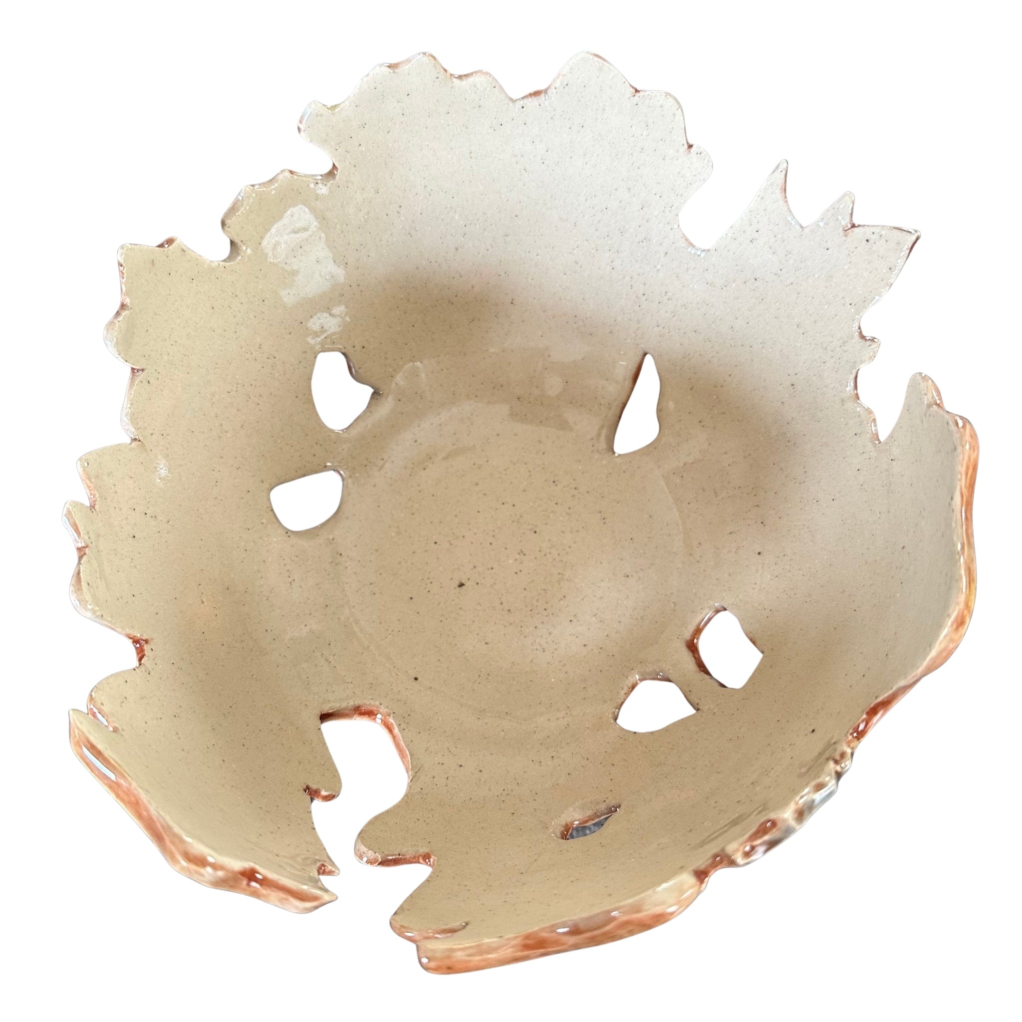 Inside view of a handmade ceramic bowl with a irregular hand-carved edge and cutout details, shown on a plain white background.