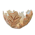 Carved leaf stoneware yarn bowl glazed in muted fall tones on a white background