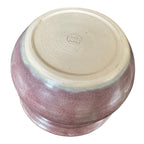 A round ceramic pot shown from a top-down angle, featuring a purple glaze on the sides and a smooth, unglazed light beige clay surface on the top.